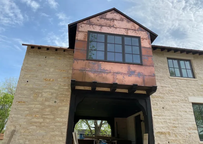 Copper metal panel facade on a stone building for Roof Repair in Minot